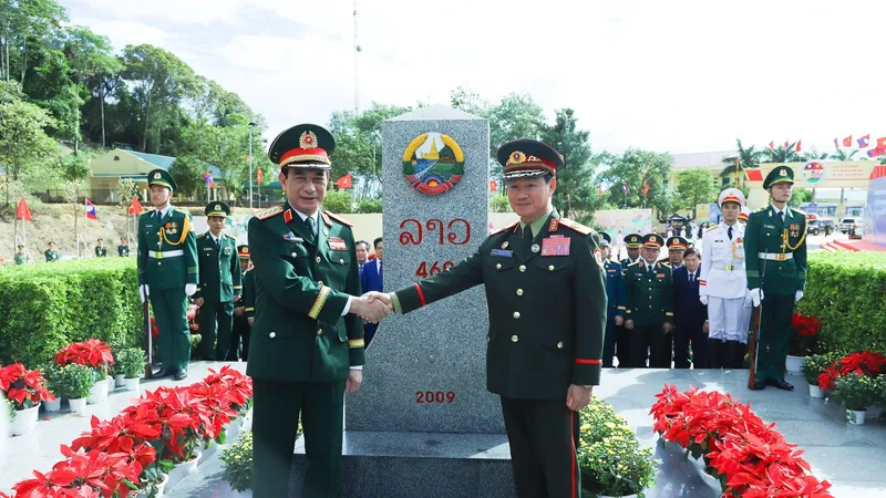 General Phan Van Giang (L) and General Khamliang Outhakaysone pose for a commemorative photo at Border Marker No. 460 on the Lao side. (Photo: SGGP)